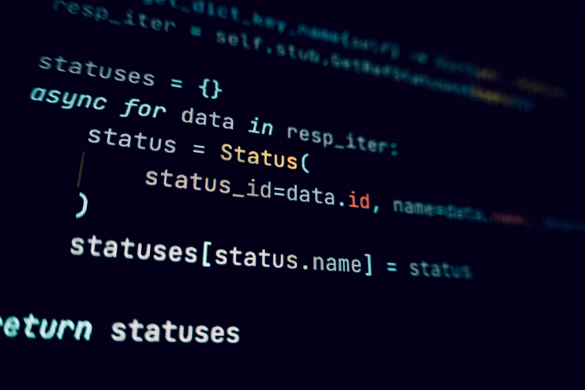 A developer laptop showing Python TaskGroup code in an IDE